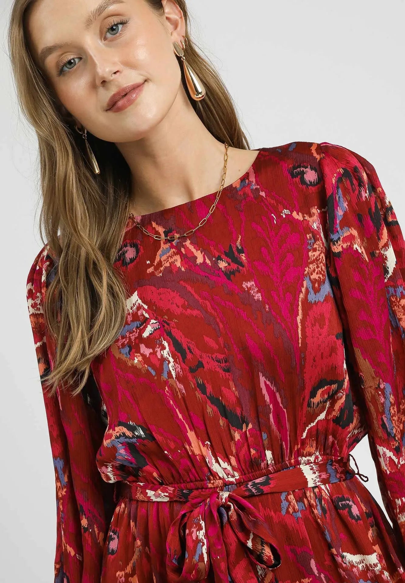 Woman wearing a red patterned dress on a white background