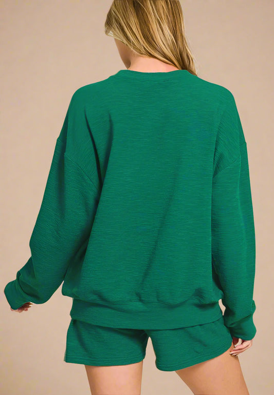 Green sweatshirt and shorts set on a white background