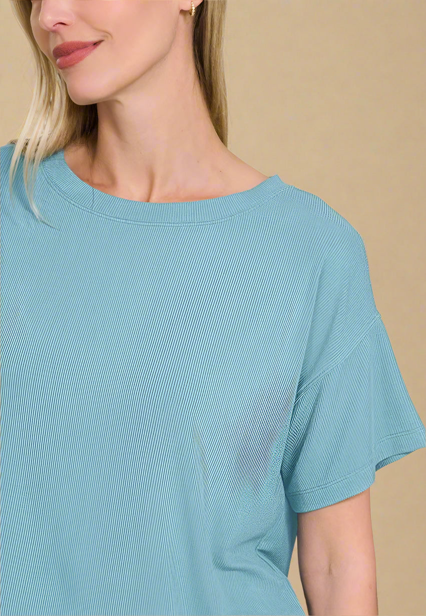 Woman wearing a light blue textured top on a white background