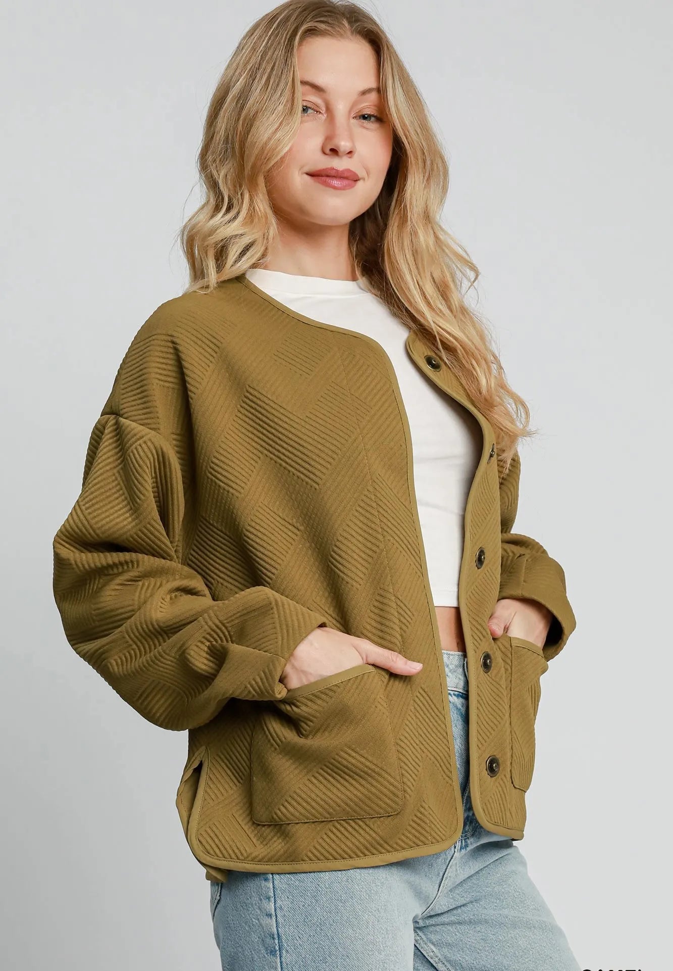 Woman wearing a camel-colored jacket on a white background