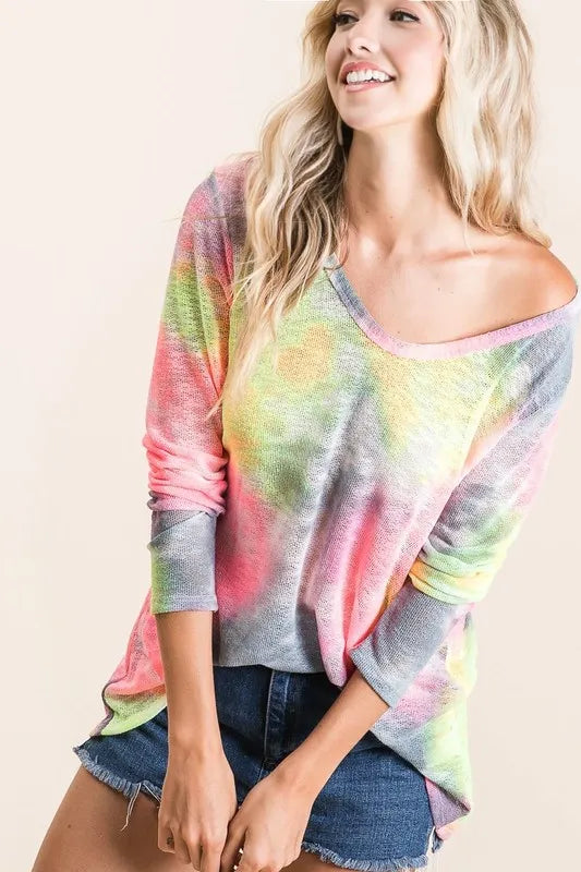 Woman wearing a colorful tie-dye sweater on a beige background