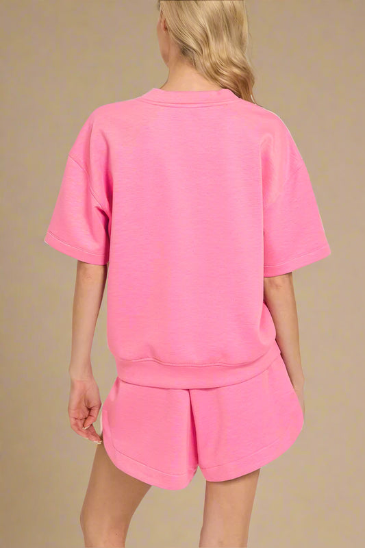 Person wearing a pink outfit on a beige background
