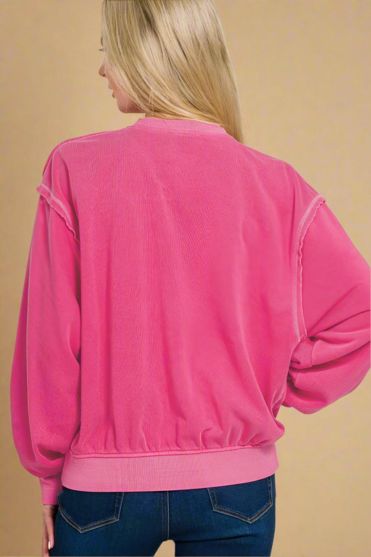 Pink sweatshirt worn by a person on a white background
