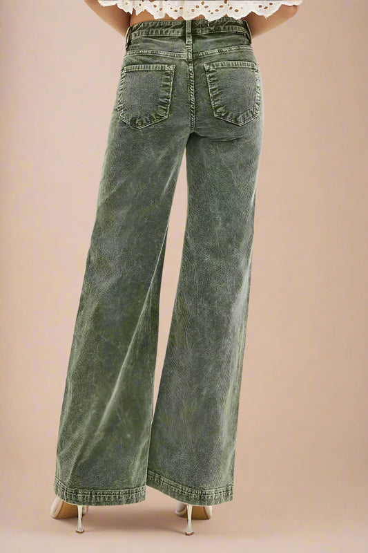 Green wide-leg jeans worn by a person on a white background
