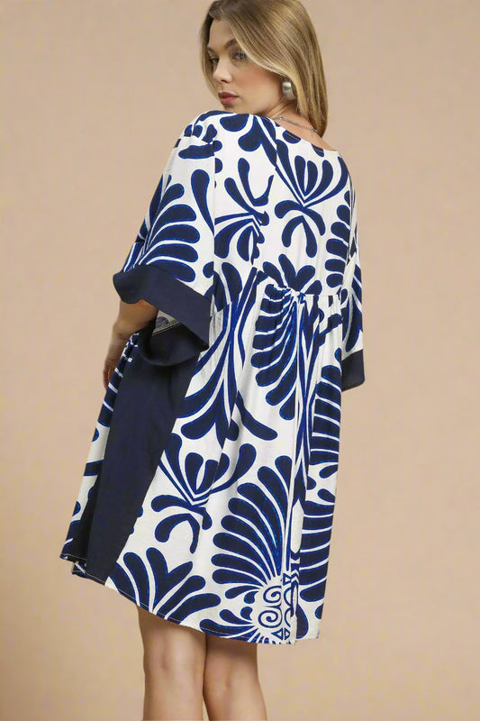 Woman wearing a blue and white patterned dress on a beige background