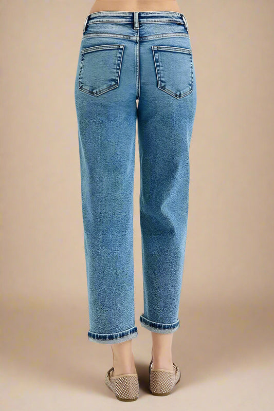 Blue jeans worn by a person on a white background