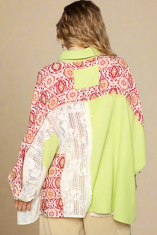 Person wearing a colorful patterned jacket over a green shirt on a plain background