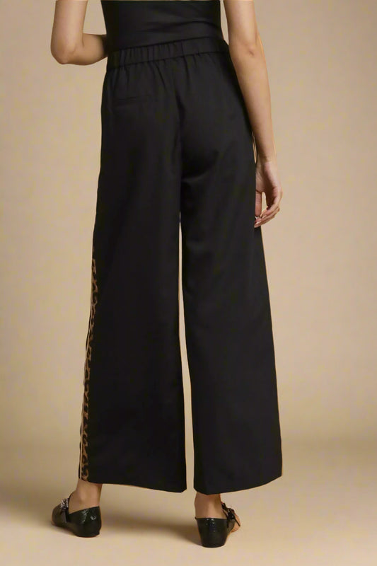 Black wide-leg pants with a side slit on a brown background