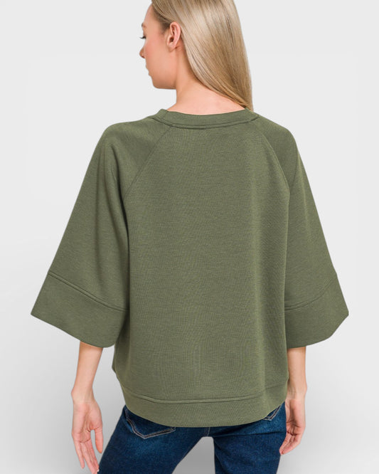 Person wearing an olive green sweater on a white background