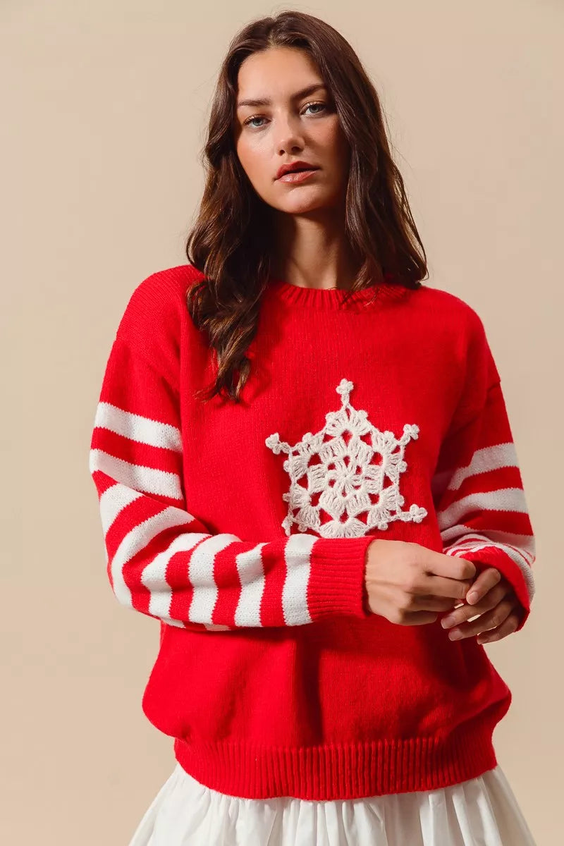 Woman wearing a red sweater with a white snowflake design on a beige background