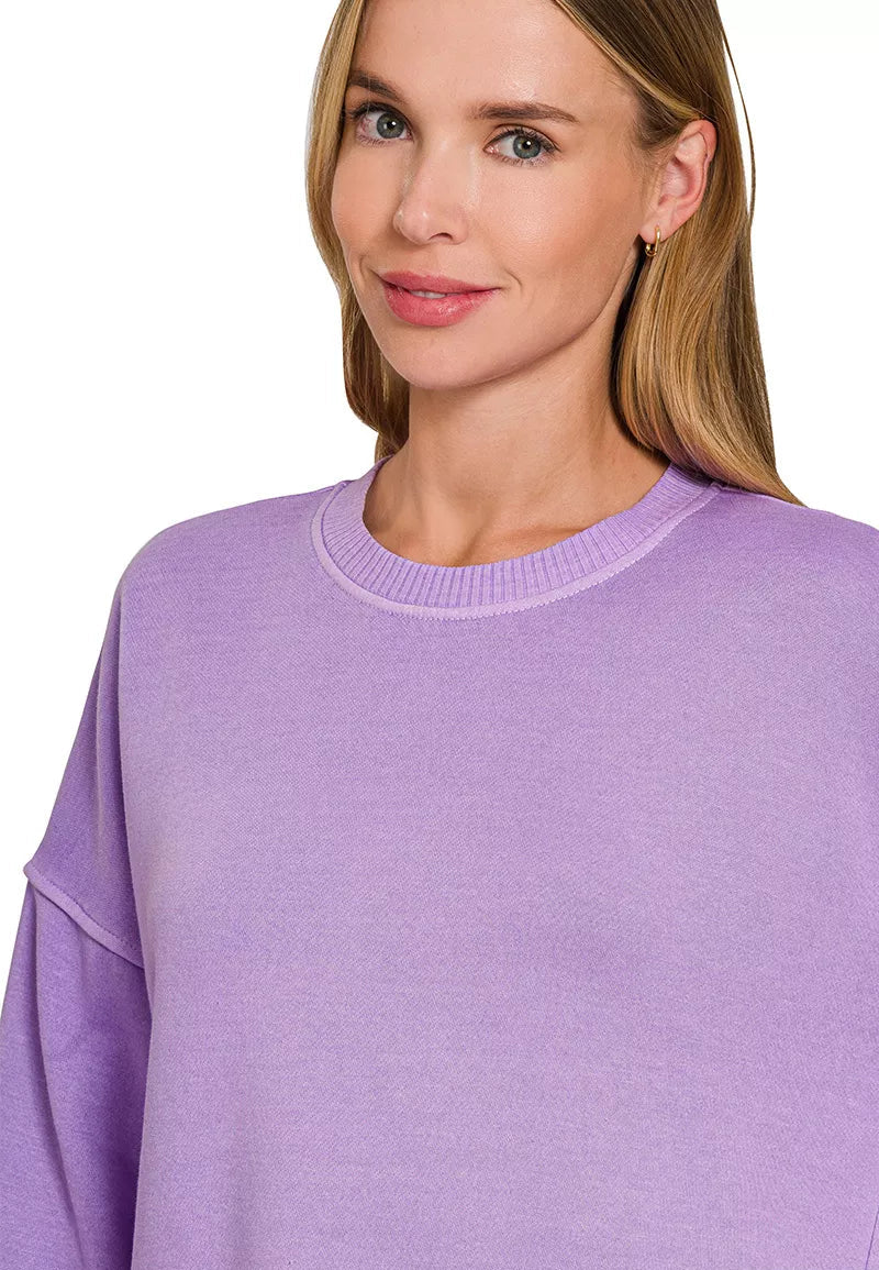 Woman wearing a lavender sweater with a plain background