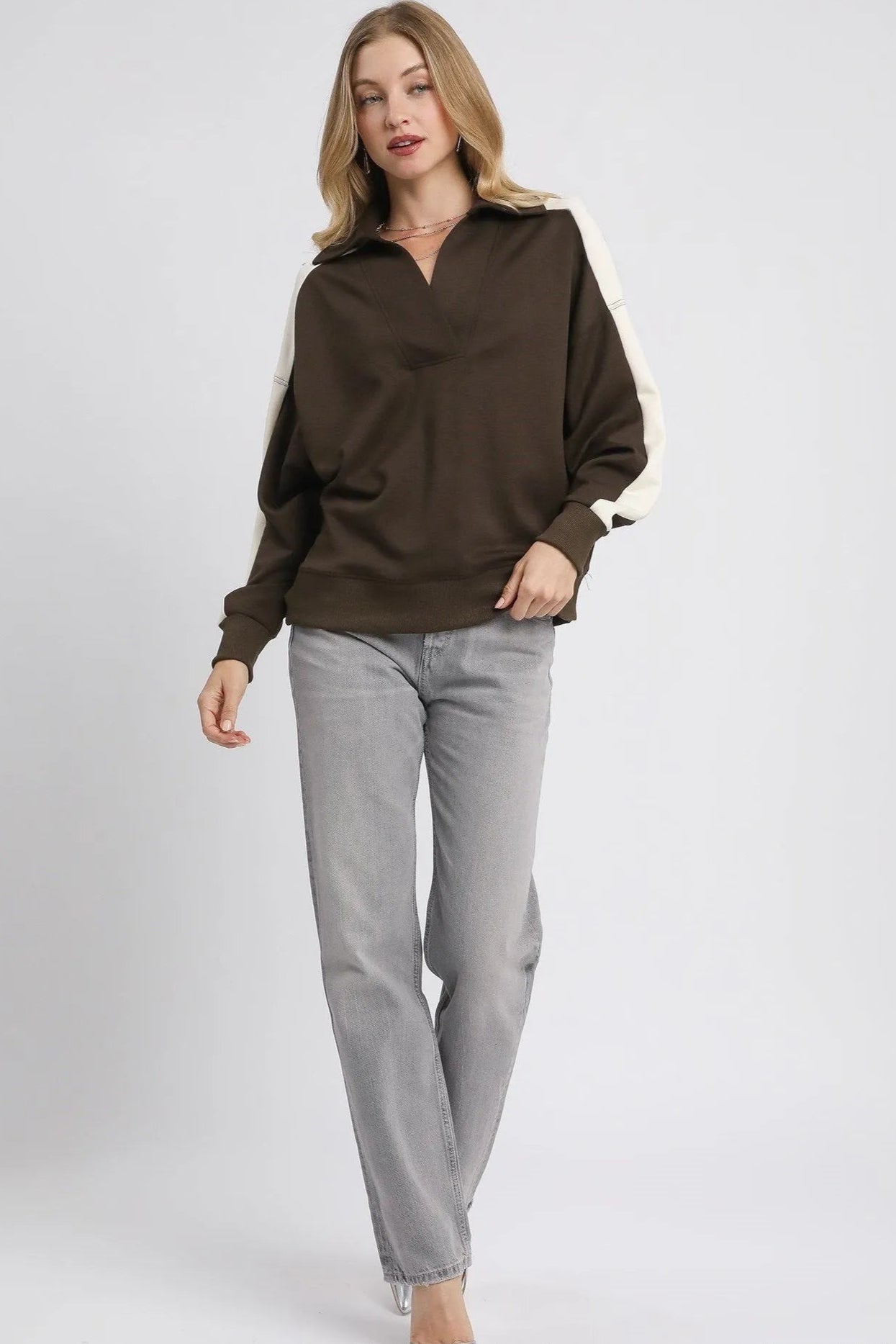 Woman wearing a brown shirt and gray pants on a white background