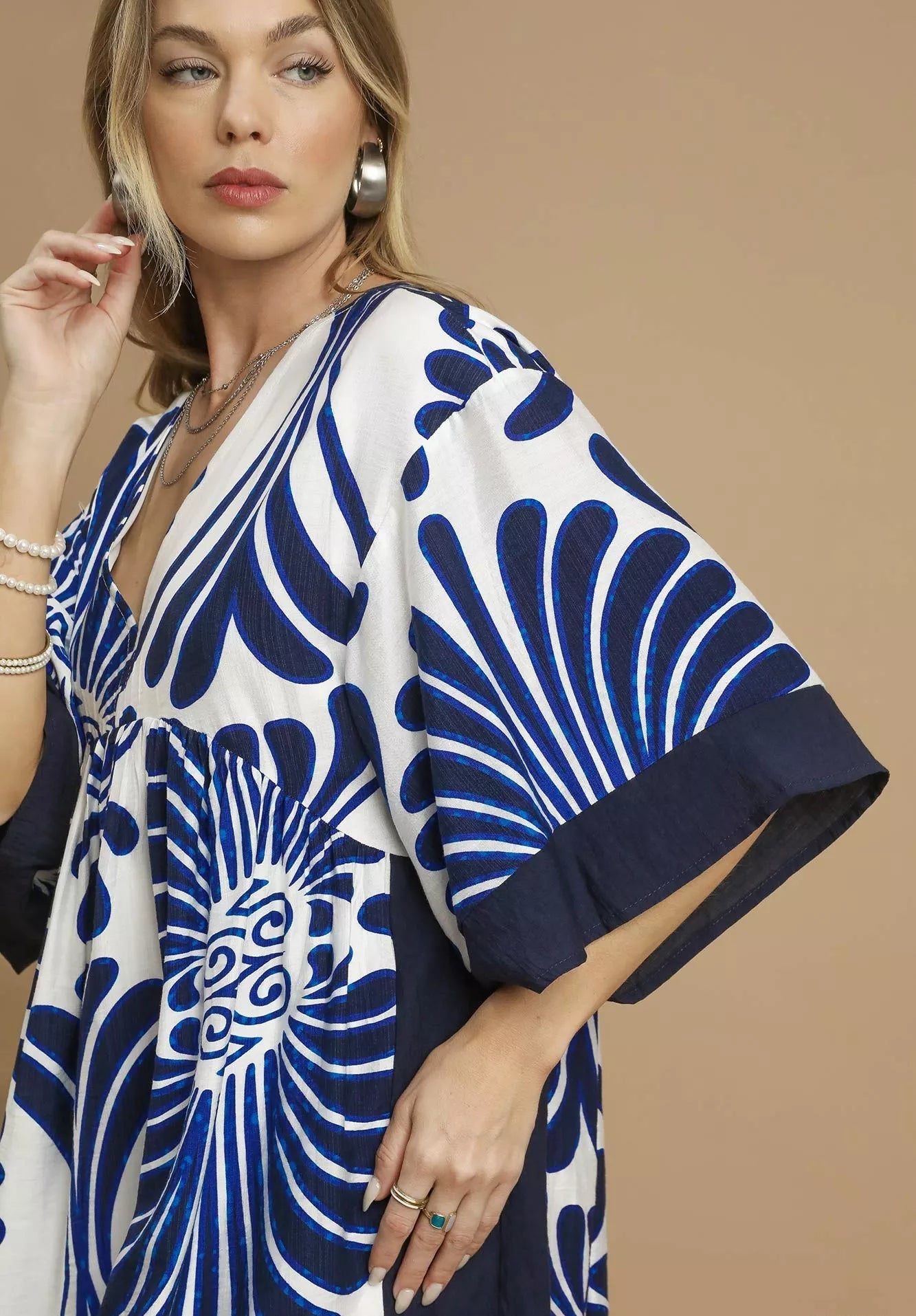 Woman wearing a blue and white patterned kimono against a beige background