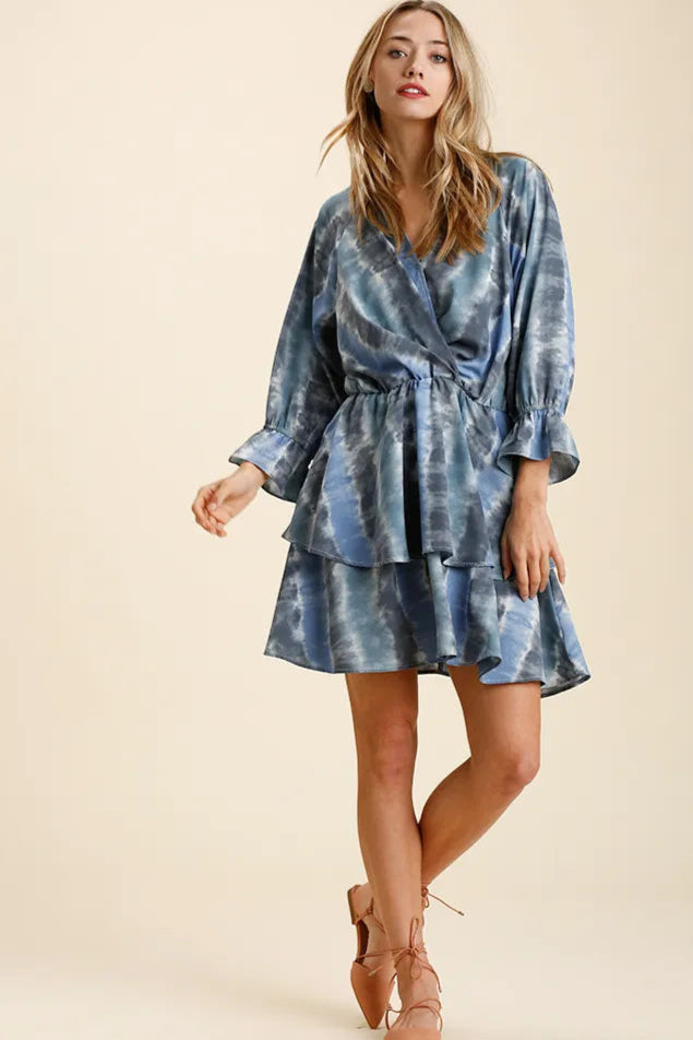 Woman wearing a blue tie-dye dress on a beige background