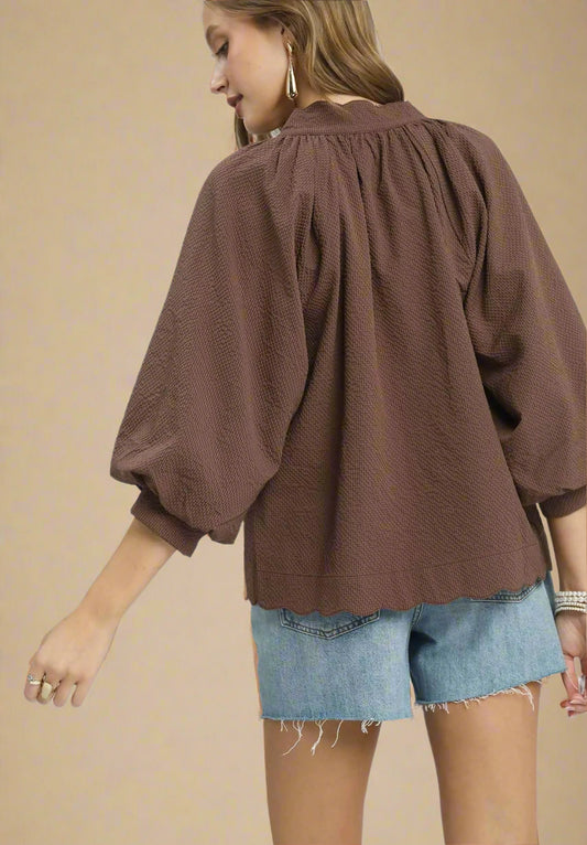 Brown blouse with balloon sleeves worn by a person on a white background