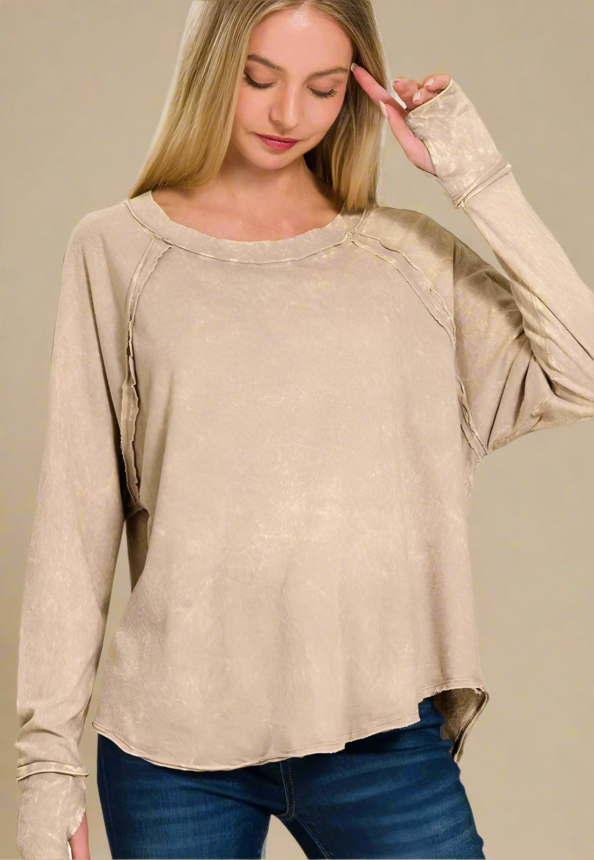 Woman wearing a beige long-sleeve top with on a beige background