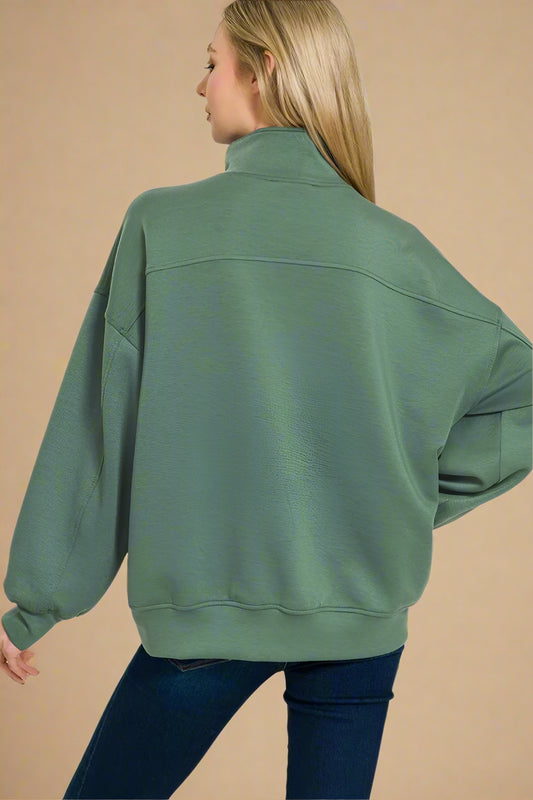 Person wearing a green sweatshirt on a beige background