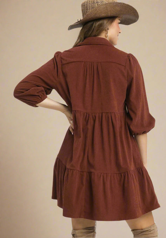 Woman wearing a brown dress with a hat on a beige background