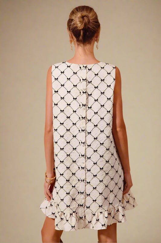 Woman wearing a sleeveless dress with a geometric pattern on a beige background