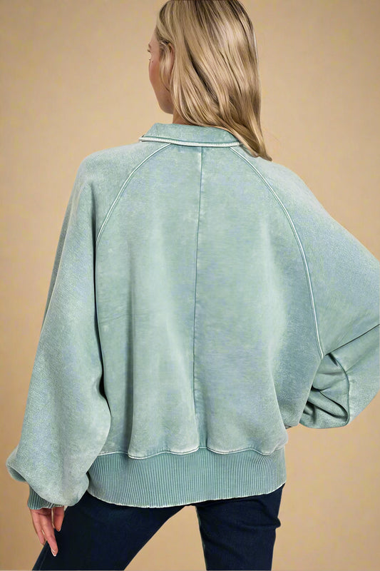 Woman wearing a light blue sweatshirt with a beige background