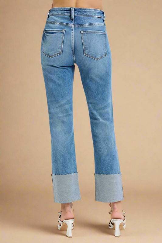 Blue jeans with cuffed hem on a white background