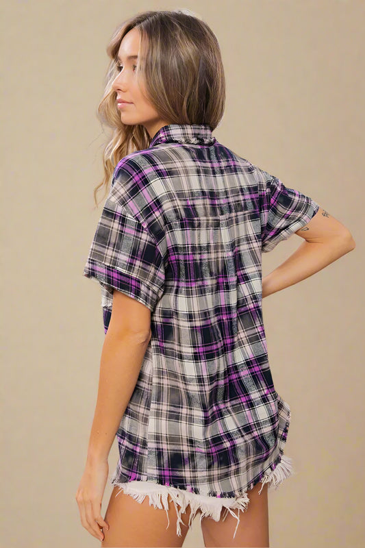 Woman wearing a plaid shirt and shorts in a home setting with decor elements.