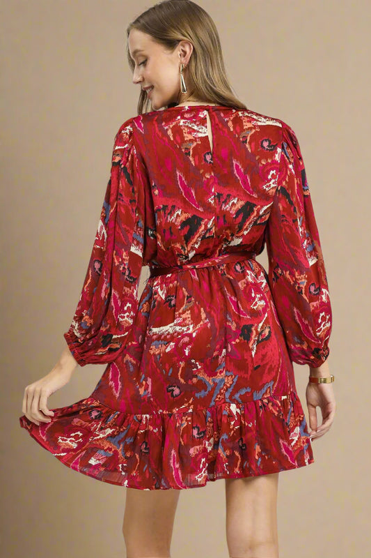 Red patterned dress worn by a model on a beige background