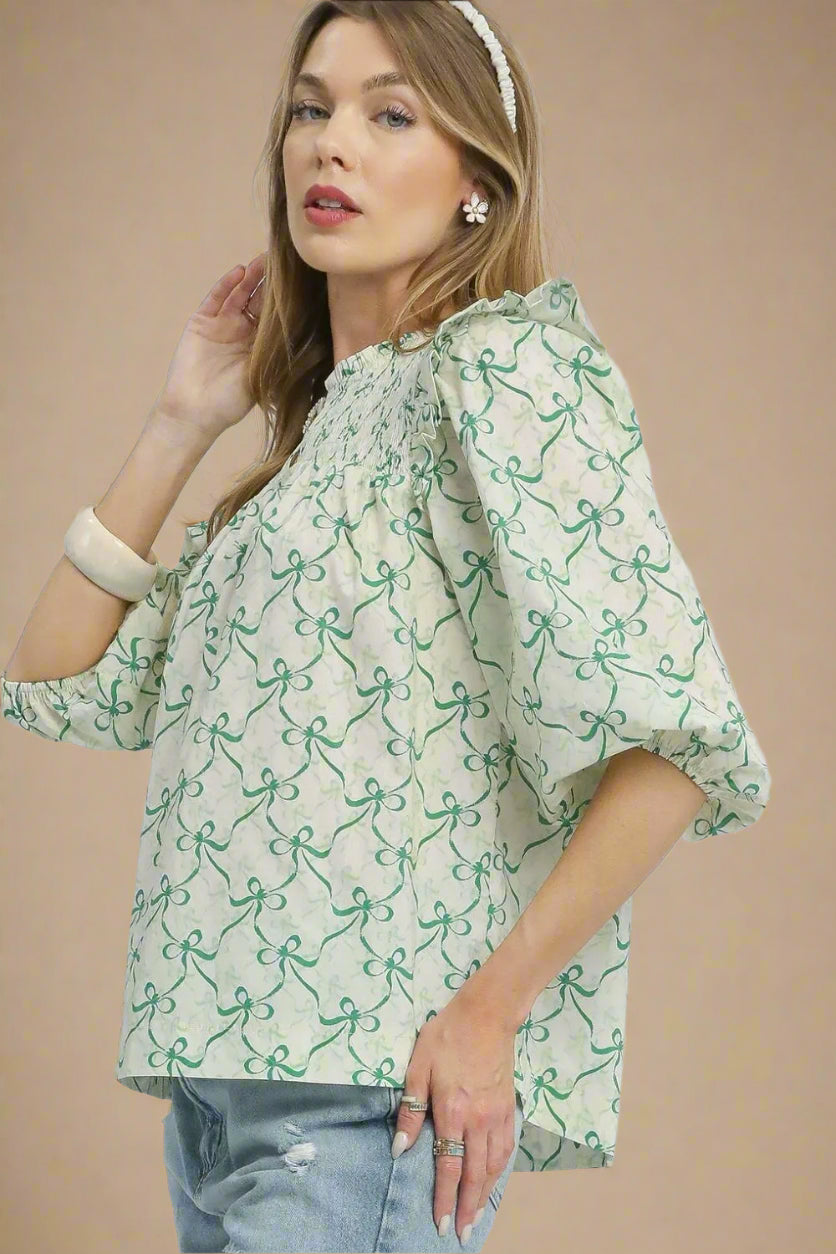 Woman wearing a green and white patterned blouse on a beige background