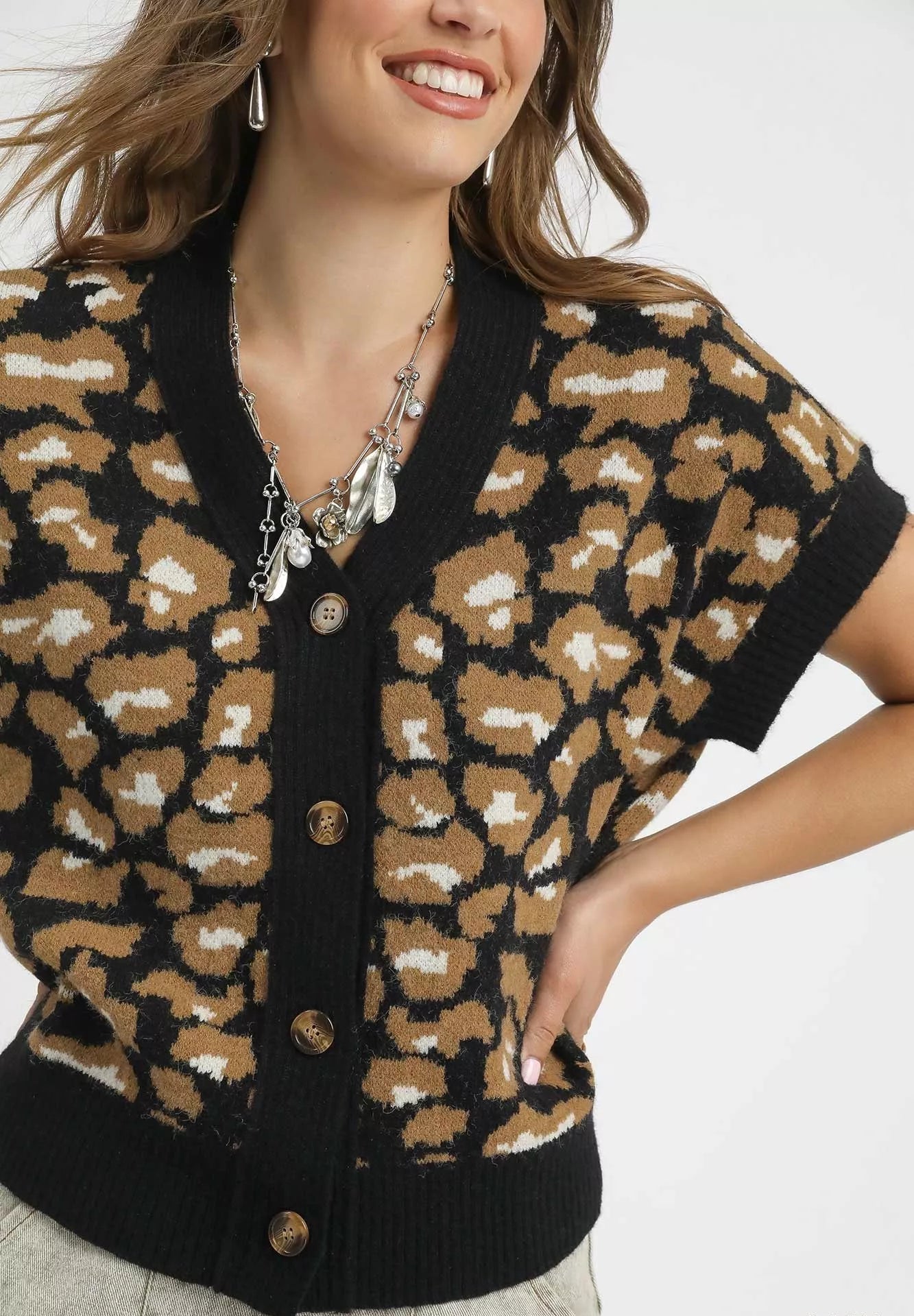 Woman wearing a leopard print cardigan with a plain background