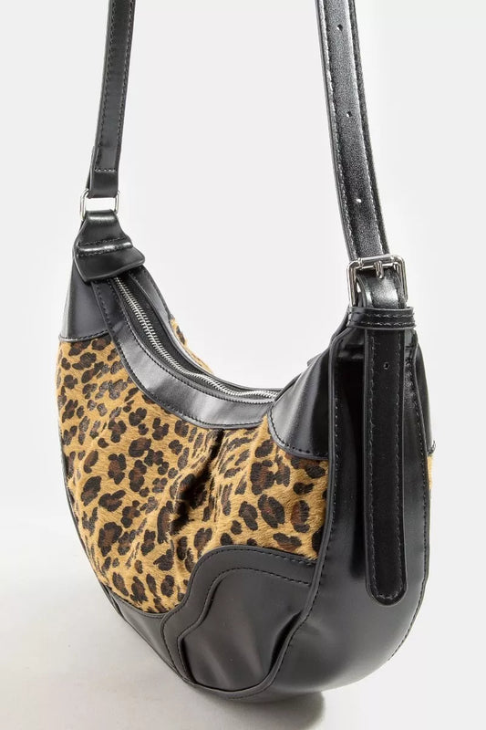 Handbag with leopard print and black leather accents on a white background