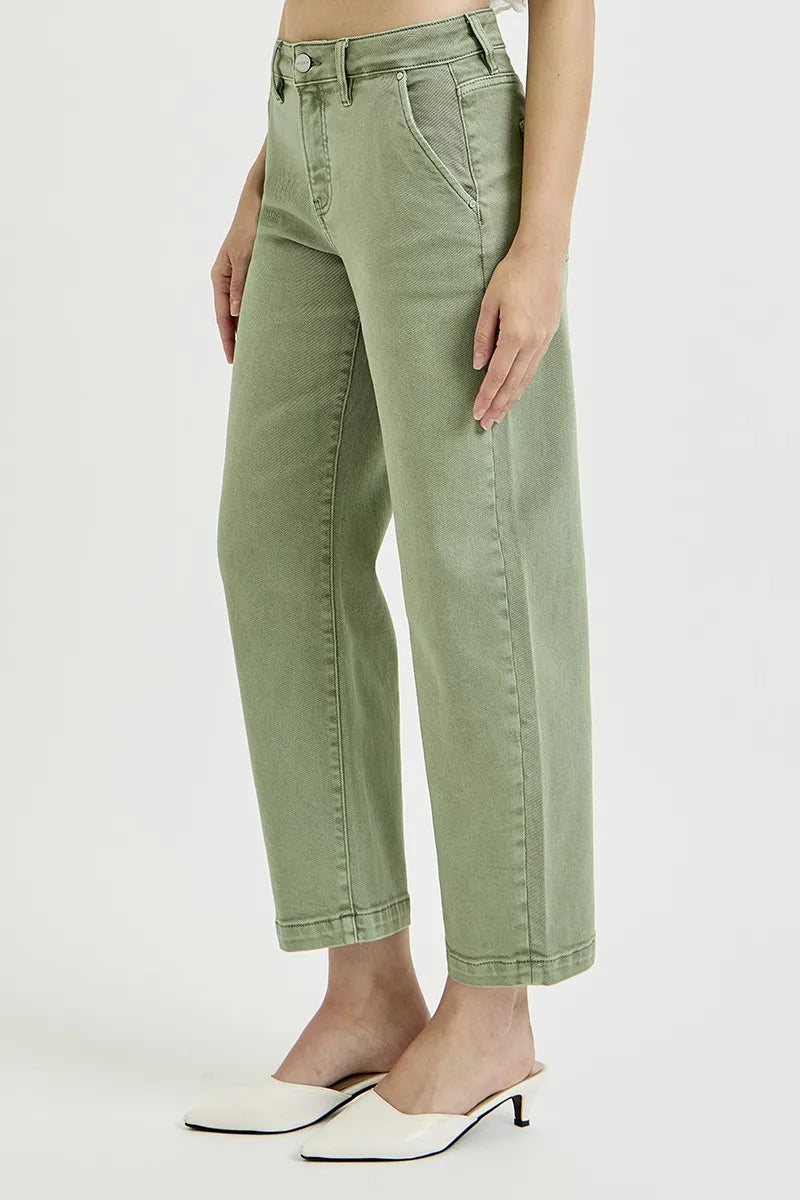 Person wearing green jeans on a white background