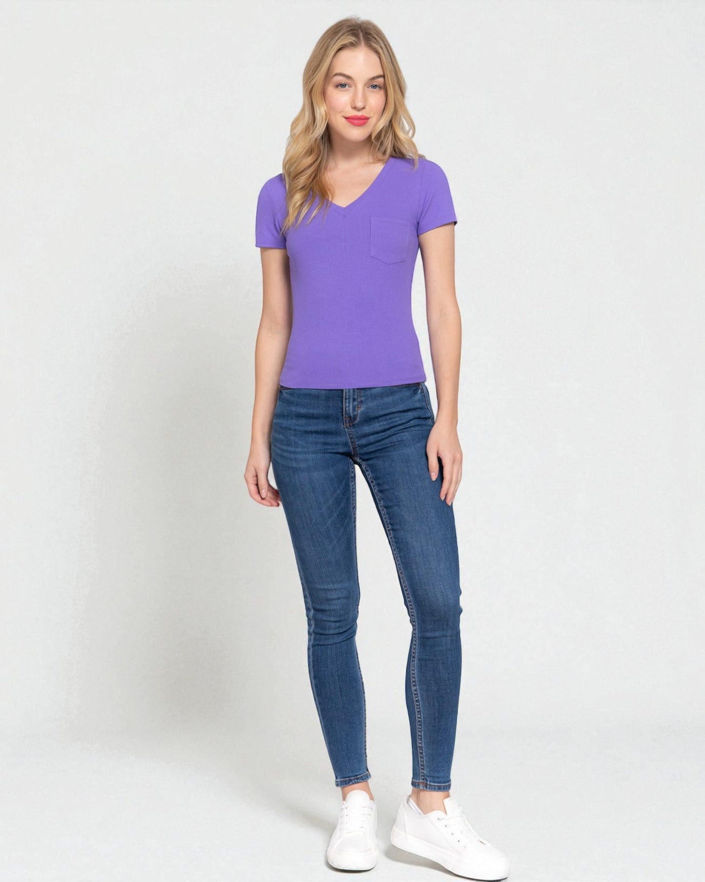 Woman wearing a purple shirt and blue jeans on a white background
