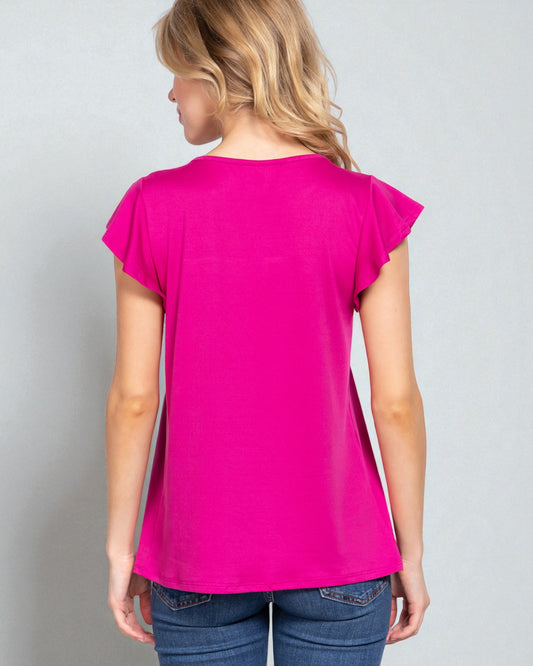 Woman wearing a bright pink t-shirt against a plain background