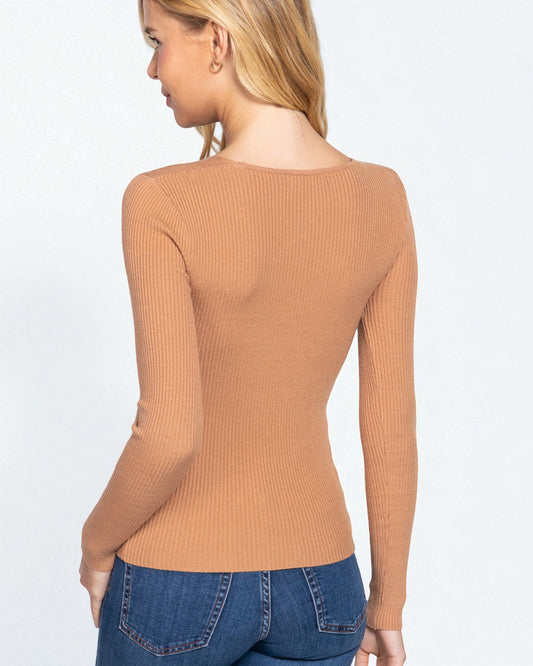 Woman wearing a brown ribbed sweater and blue jeans on a white background