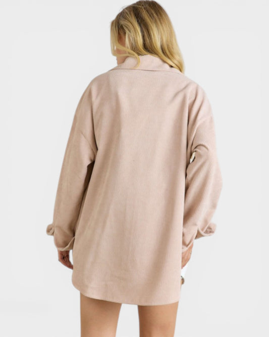 Person wearing a beige dress against a white background