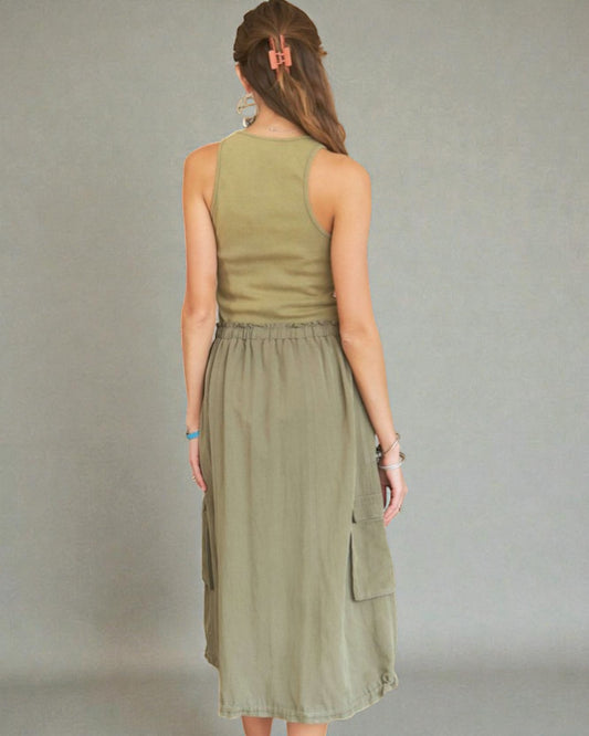 Woman wearing an olive green dress against a gray background