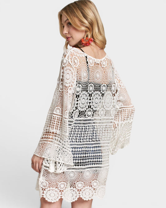 Woman wearing a white crochet dress on a white background