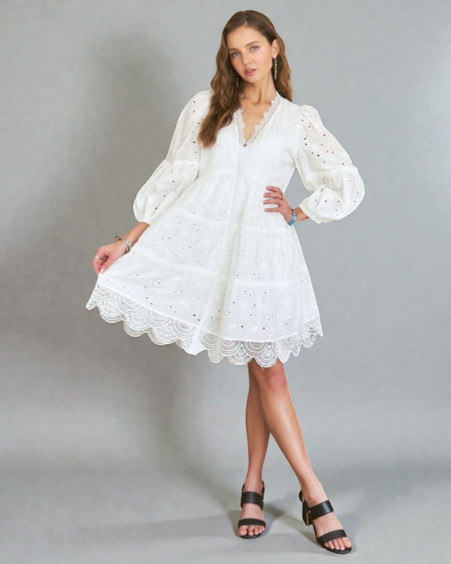 Woman wearing a white lace dress on a gray background