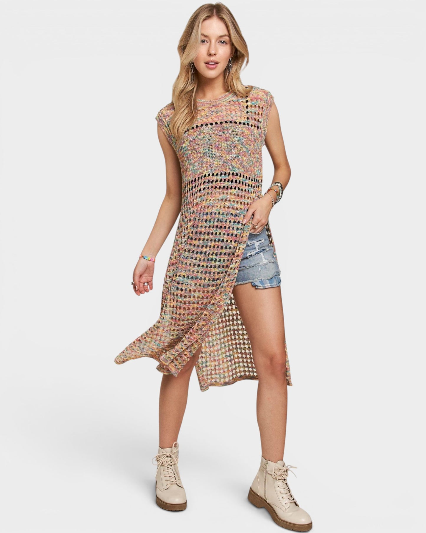 Woman wearing a colorful dress with denim shorts on a white background