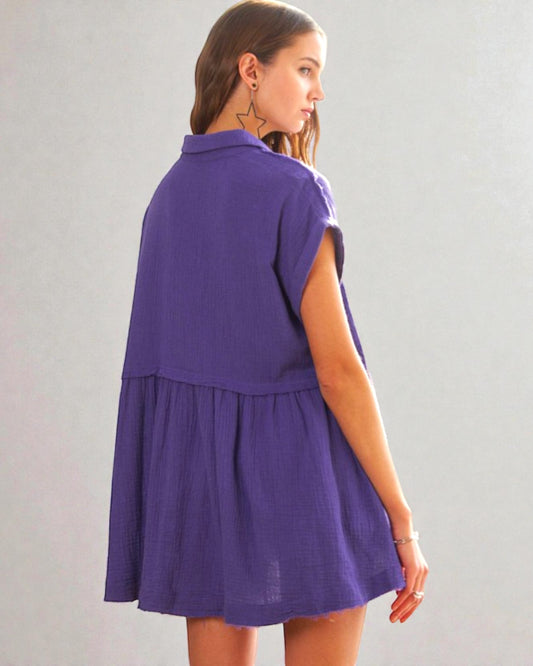 Woman wearing a purple dress against a plain background
