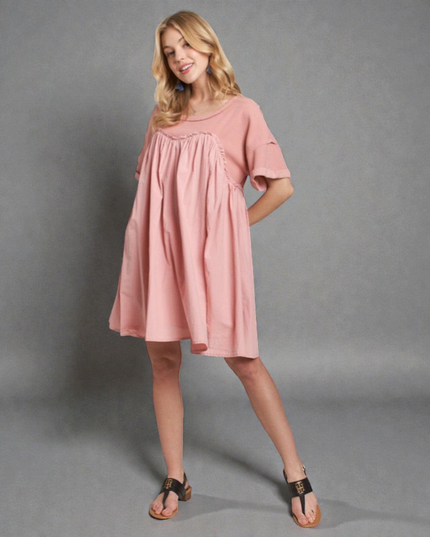 Woman wearing a pink dress against a gray background