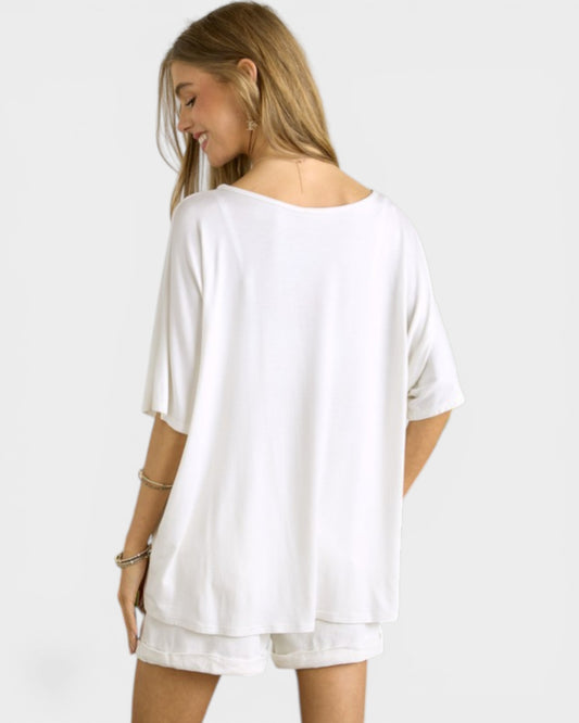 Woman wearing a white oversized t-shirt on a plain background