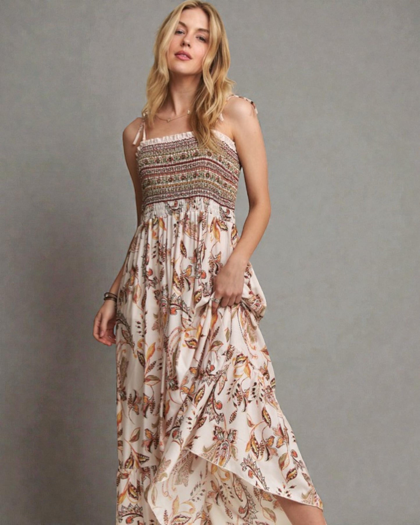 Woman wearing a patterned dress against a gray background