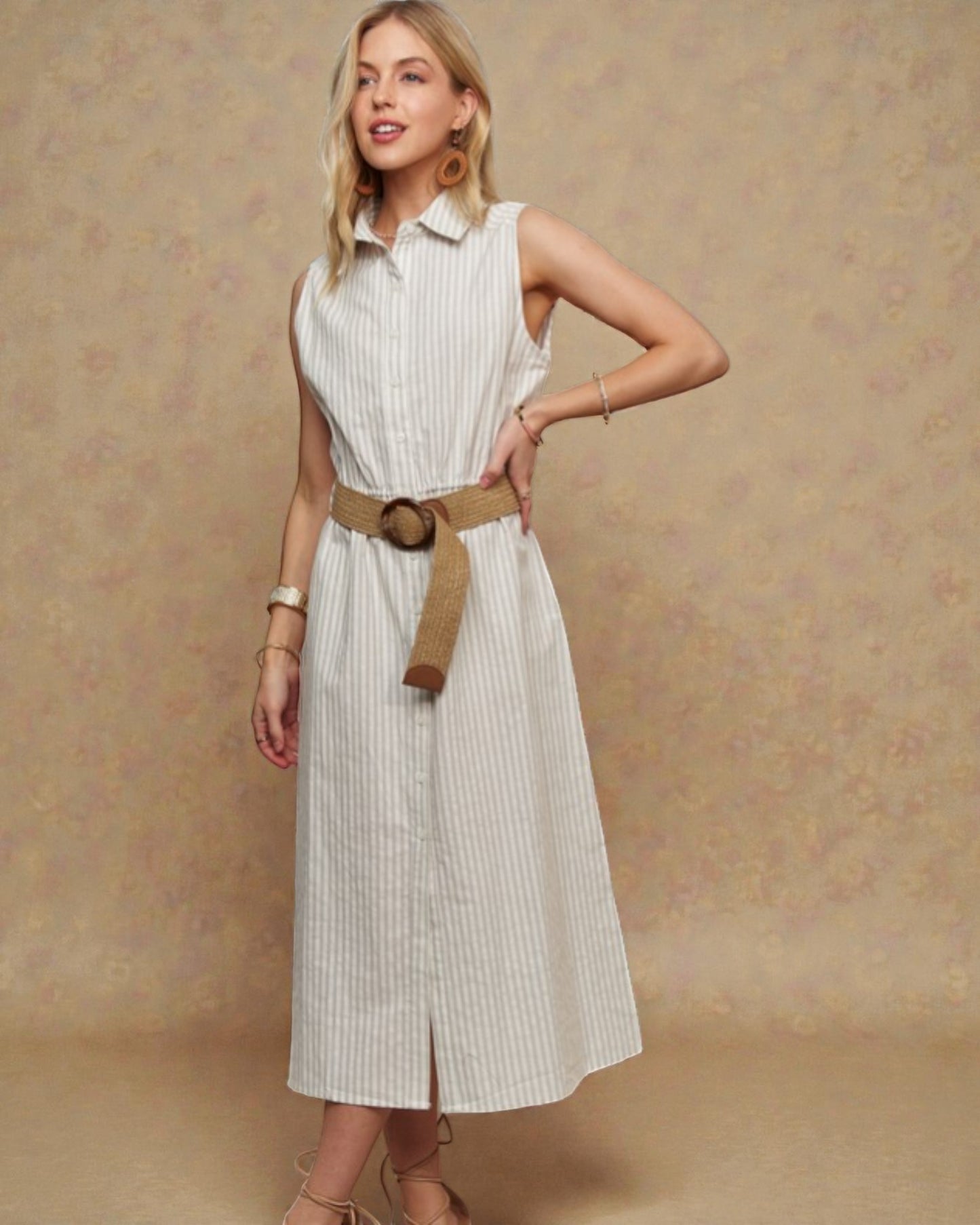 Woman wearing a white sleeveless dress with a belt against a beige background