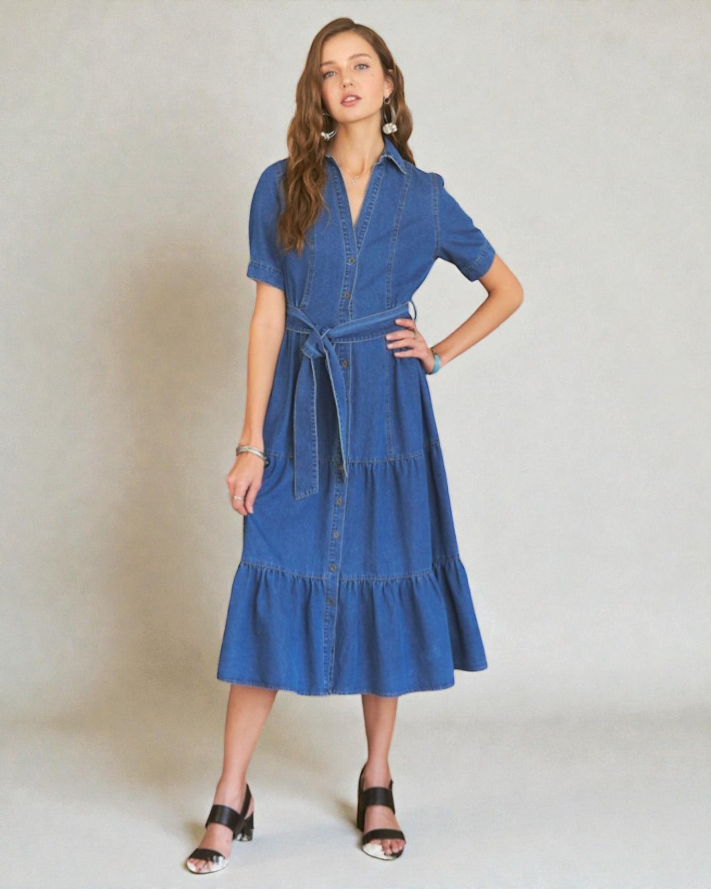 Woman wearing a blue denim dress against a plain background