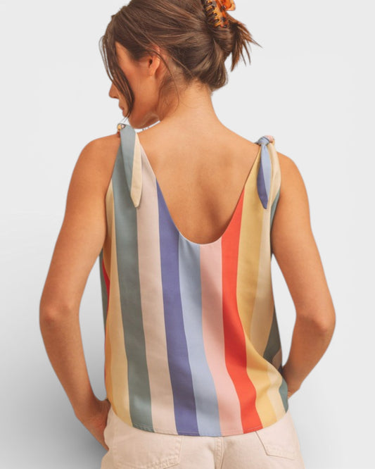 Woman wearing a multicolored striped tank top against a plain background