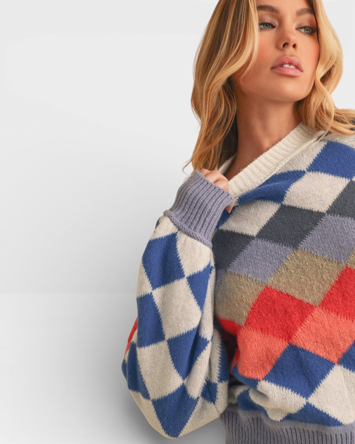 Woman wearing a colorful checkered sweater against a plain background