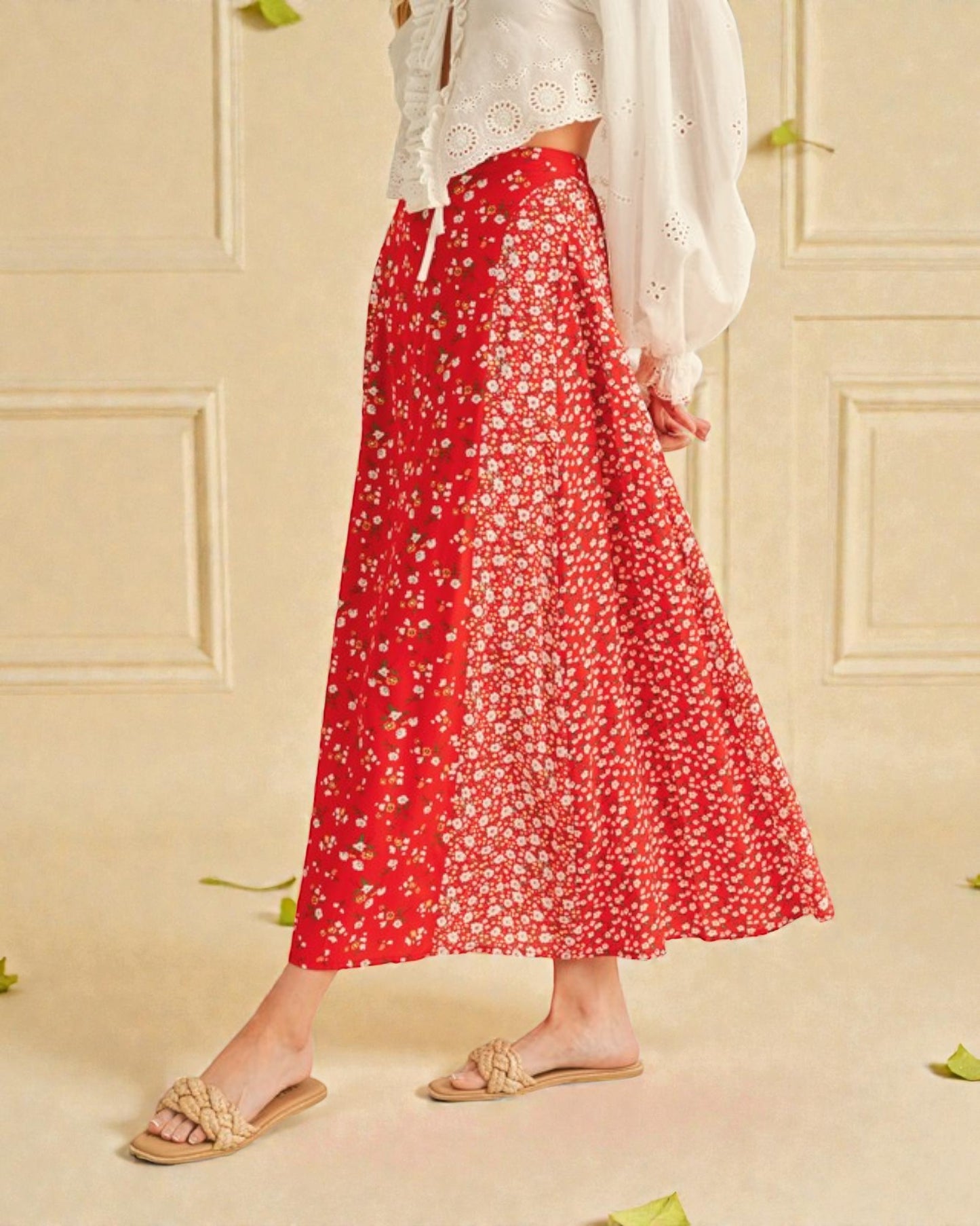 Person wearing a red floral skirt and white top against a beige wall.