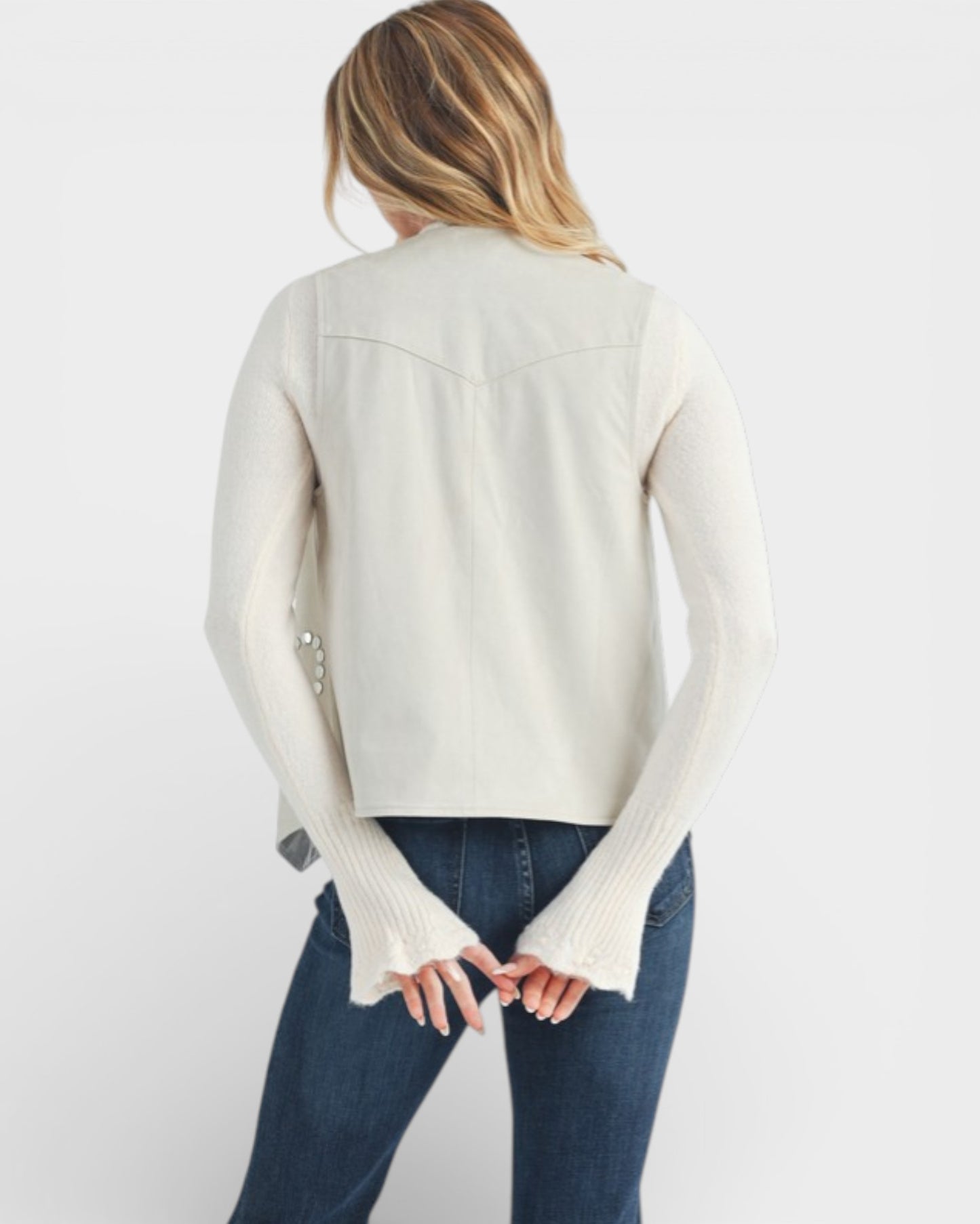 Woman wearing a cream-colored long-sleeve top with bell sleeves on a white background