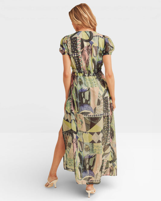 Woman wearing a patterned dress with a high slit on a white background